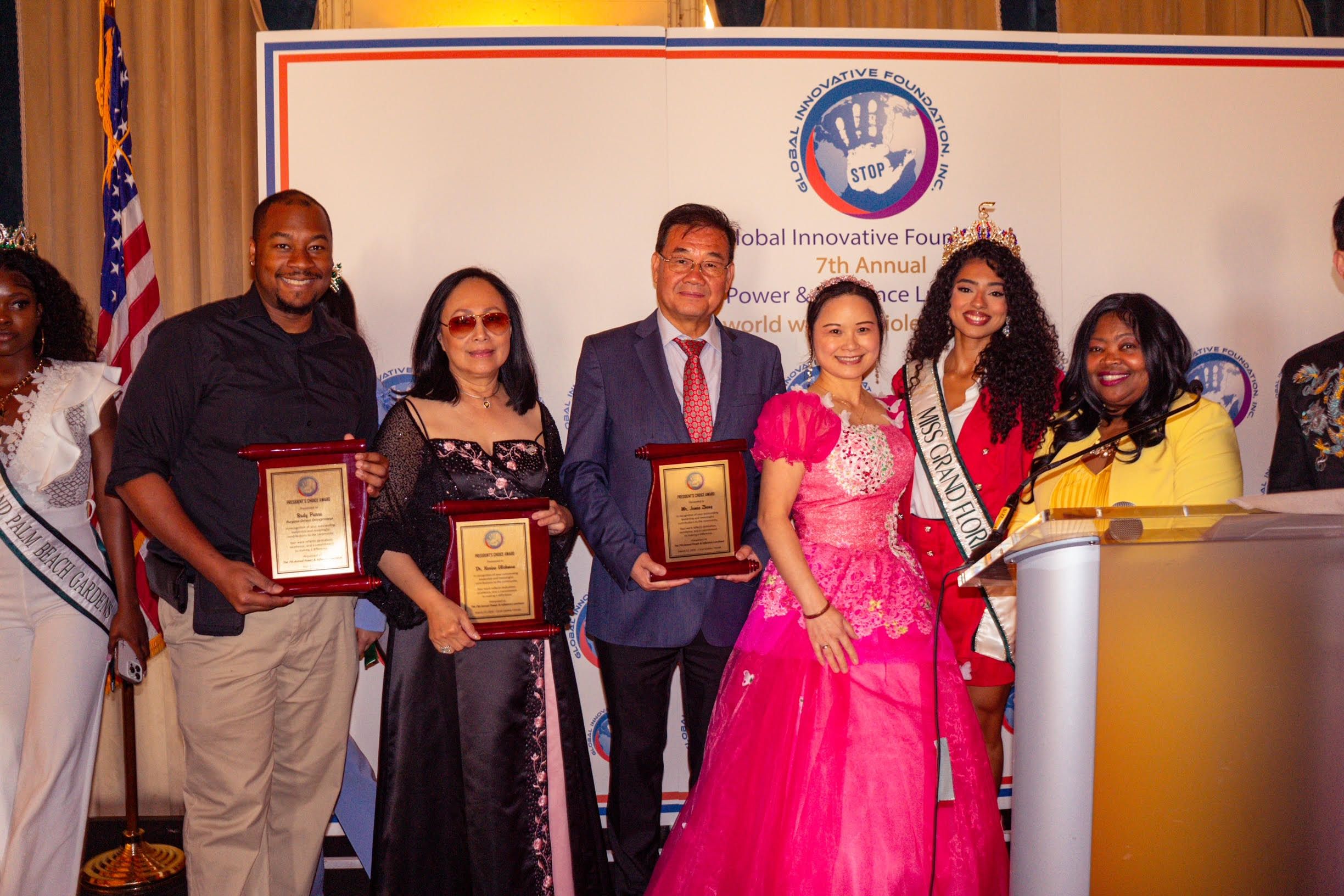 Honorees on stage with award plaques and certificates